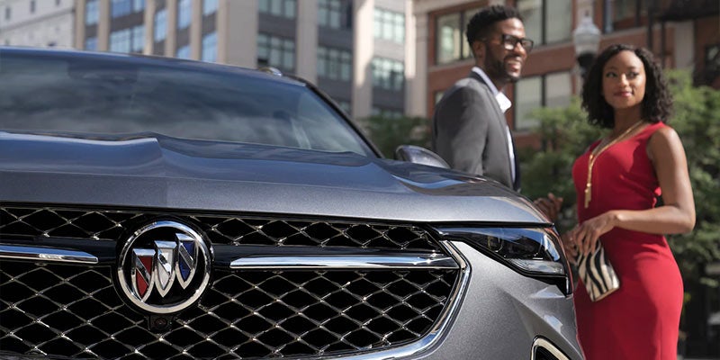 A man and women stand beside the car