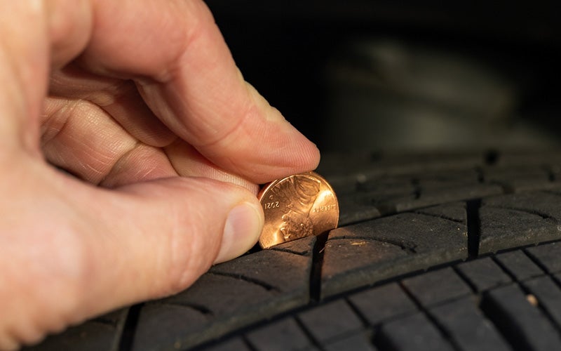 Dublin Buick GMC in Dublin CA technician checking tire with penny
